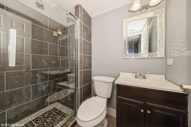 bathroom with a stall shower, vanity, and toilet