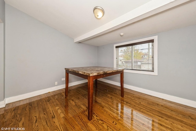 dining area featuring lofted ceiling with beams, baseboards, and wood finished floors