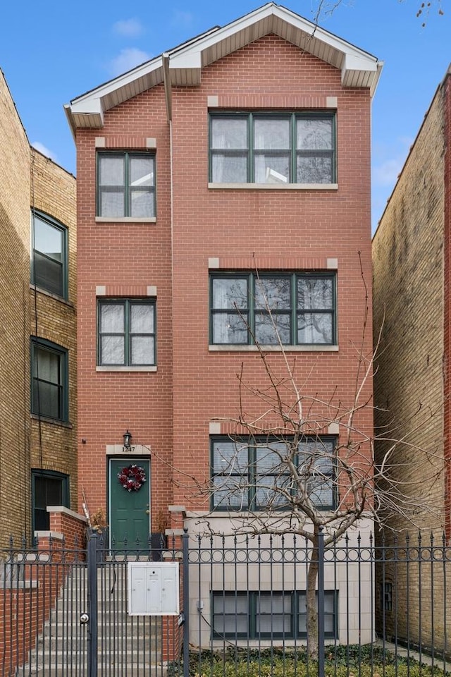 view of front of house with a fenced front yard and brick siding