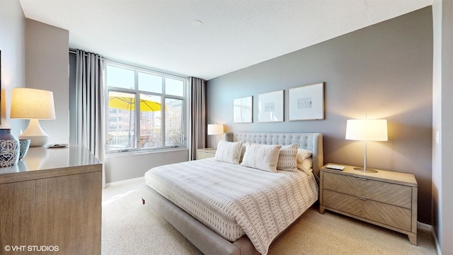 bedroom featuring baseboards and light carpet