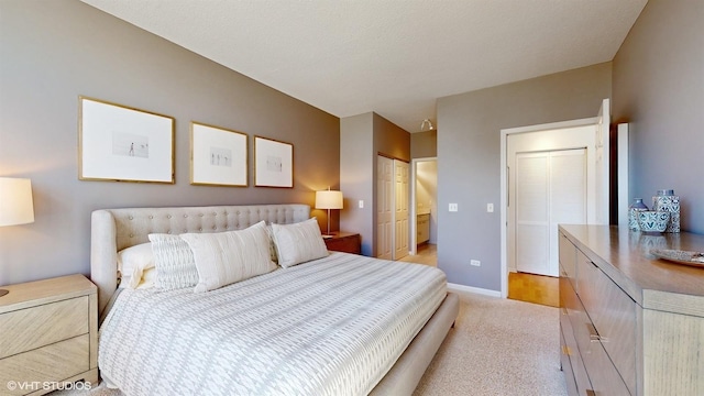 bedroom with a textured ceiling, baseboards, and light carpet