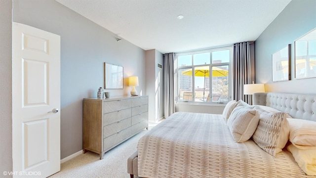 bedroom featuring light carpet and baseboards