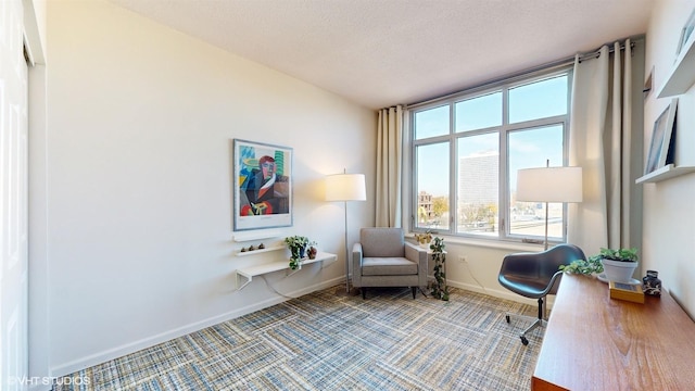 living area with carpet flooring, a textured ceiling, and baseboards