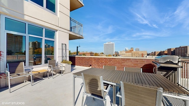 view of patio / terrace featuring a grill, a view of city, and a balcony