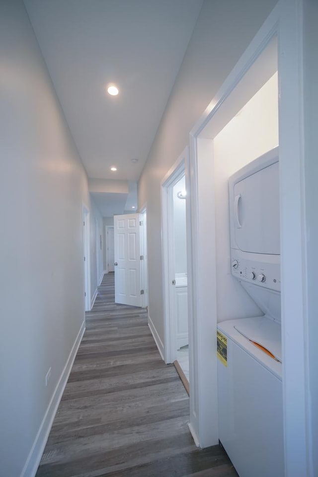 hall with stacked washer and dryer, baseboards, dark wood finished floors, and recessed lighting