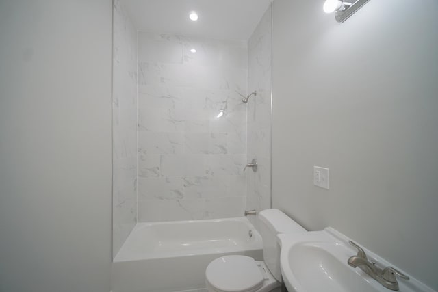 bathroom with shower / bath combination, a sink, and toilet