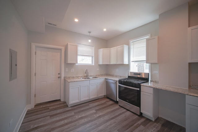 kitchen with appliances with stainless steel finishes, dark wood-style flooring, a sink, and electric panel