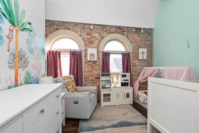 bedroom with multiple windows and brick wall