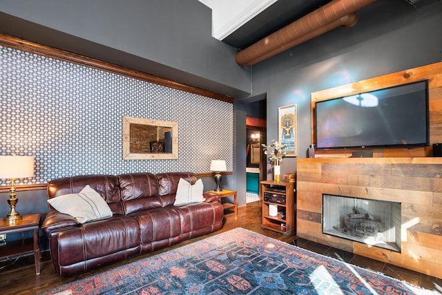 living area featuring wallpapered walls, a tiled fireplace, an accent wall, and wood finished floors