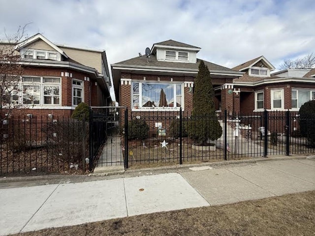 bungalow-style home with brick siding and a fenced front yard