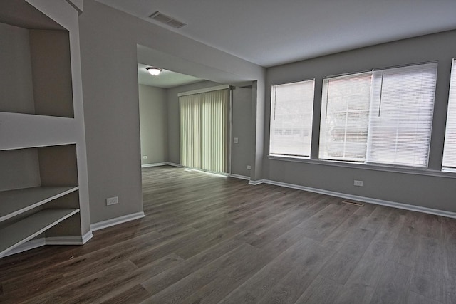 spare room with visible vents, dark wood finished floors, and baseboards