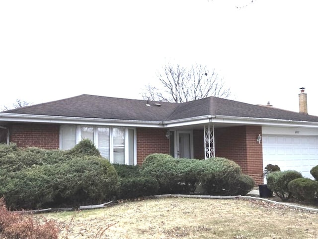 view of front of property featuring a garage, a chimney, and brick siding