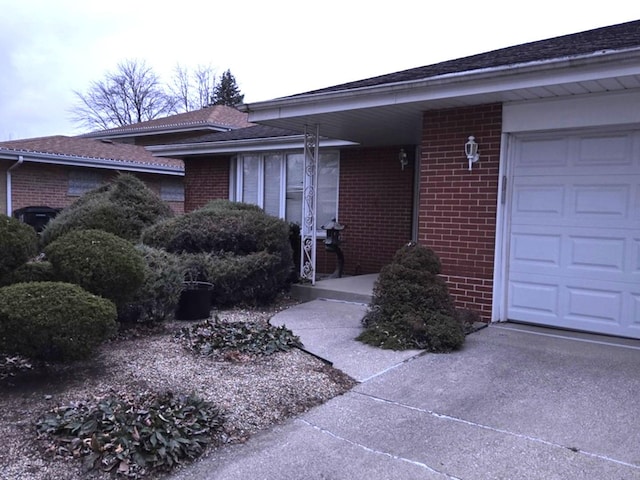 doorway to property with brick siding and an attached garage