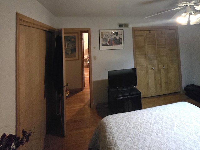 bedroom featuring ceiling fan, visible vents, a closet, and wood finished floors