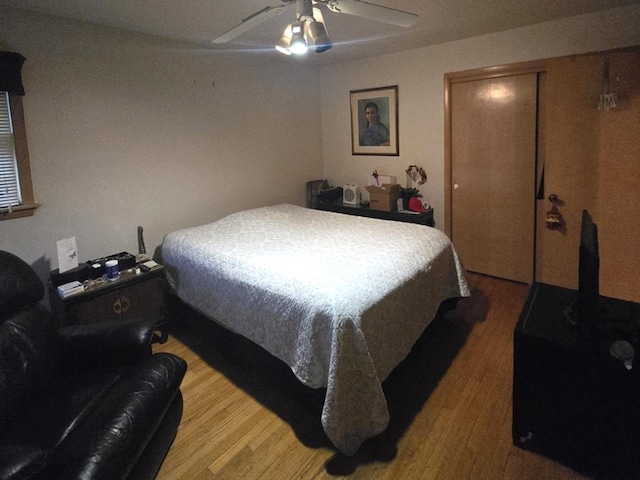 bedroom with a closet, wood finished floors, and a ceiling fan