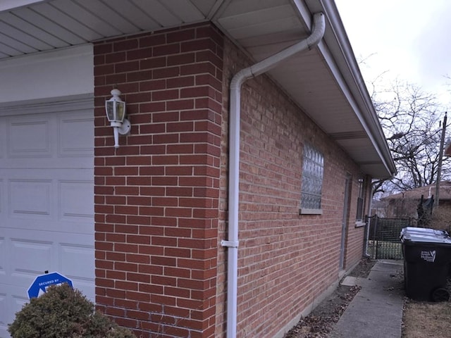 view of side of property with a garage and brick siding