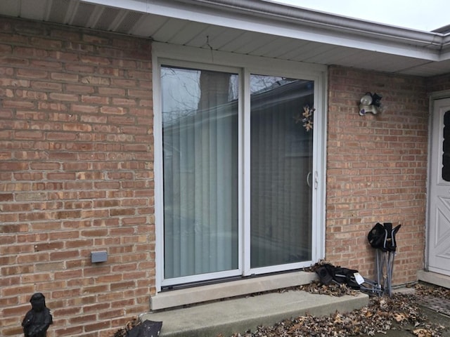 doorway to property featuring brick siding