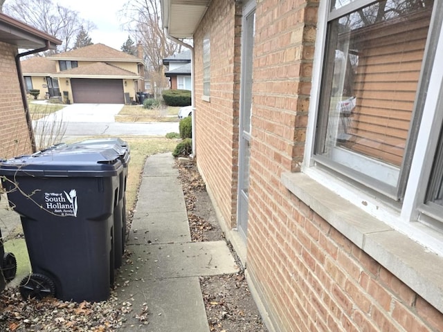 view of property exterior featuring a garage and brick siding