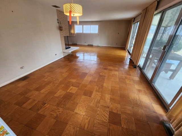 unfurnished living room with visible vents and baseboards