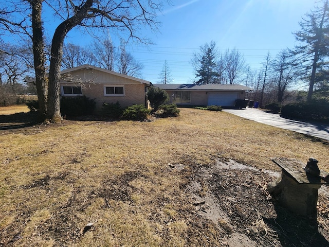 view of front of home featuring brick siding, an attached garage, and driveway