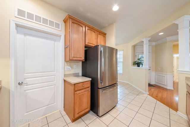 kitchen featuring visible vents, ornate columns, light tile patterned flooring, freestanding refrigerator, and light countertops