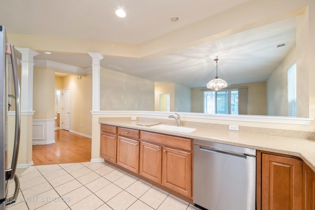 kitchen featuring pendant lighting, a sink, appliances with stainless steel finishes, light tile patterned floors, and ornate columns