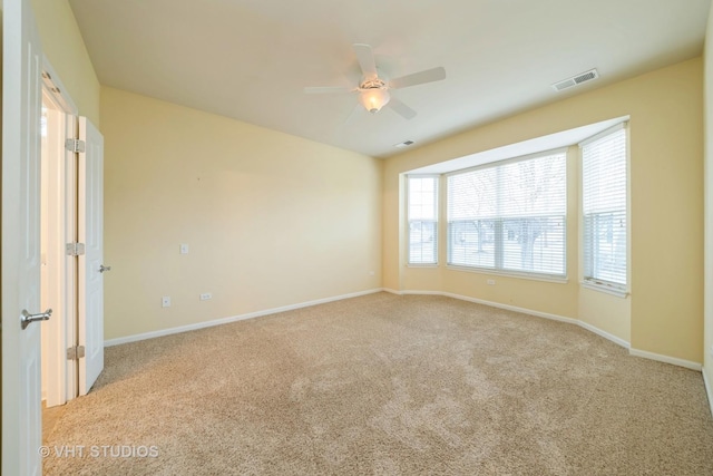 unfurnished room featuring visible vents, ceiling fan, baseboards, and carpet