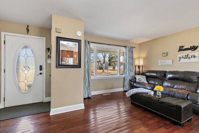 living area with visible vents, baseboards, and wood finished floors