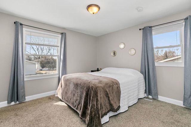 carpeted bedroom with multiple windows and baseboards