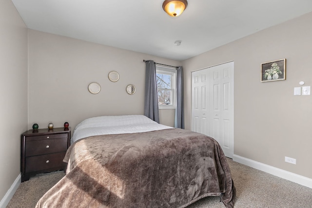 carpeted bedroom featuring baseboards and a closet