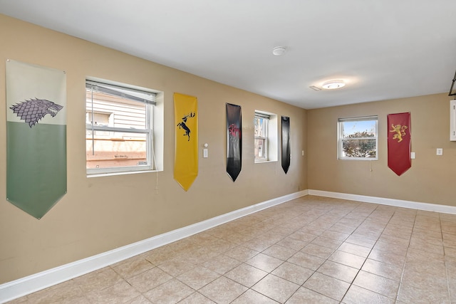 unfurnished room featuring light tile patterned floors and baseboards