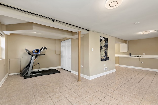 exercise area with light tile patterned floors and baseboards