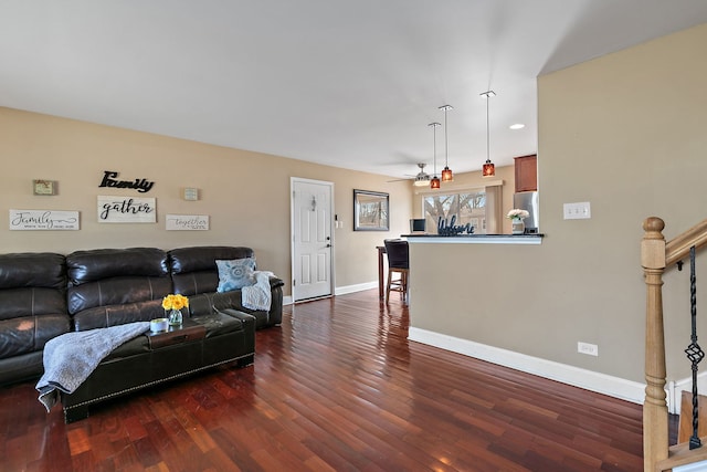 living room featuring dark wood-style floors, ceiling fan, stairs, and baseboards