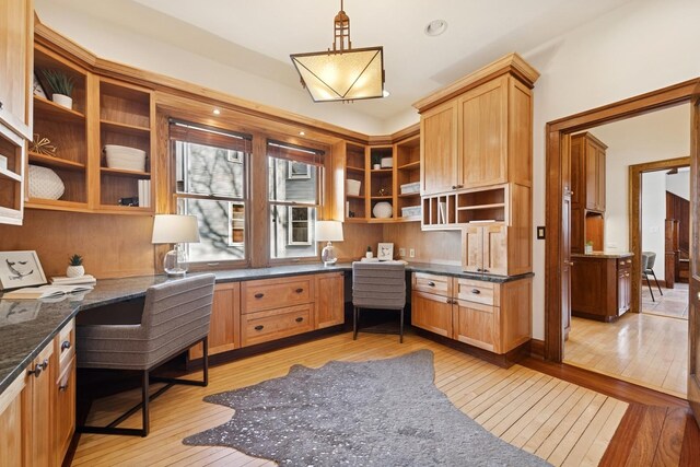 office space with built in study area and light wood-style floors