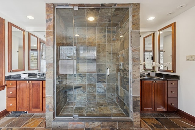 bathroom with a sink, a stall shower, and two vanities