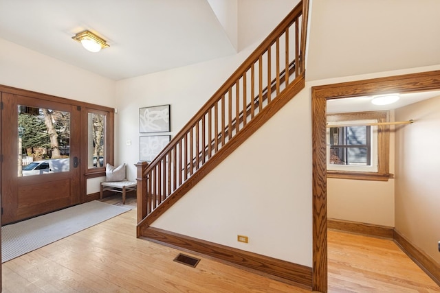 entryway featuring stairway, light wood-style flooring, visible vents, and baseboards