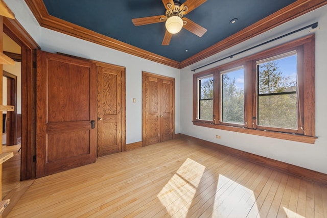 unfurnished bedroom featuring ornamental molding, light wood-type flooring, and baseboards