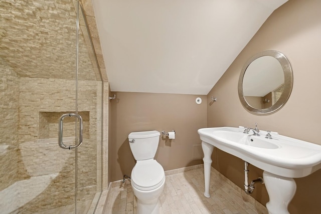 bathroom with lofted ceiling, a shower stall, toilet, and baseboards