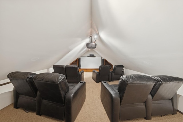 cinema room with light carpet and vaulted ceiling