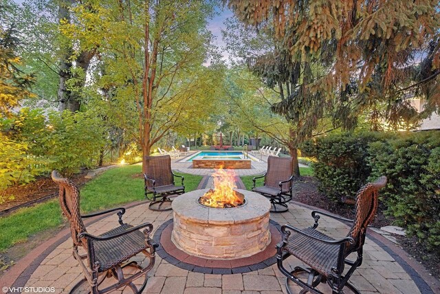 view of patio / terrace with an outdoor fire pit and an outdoor pool