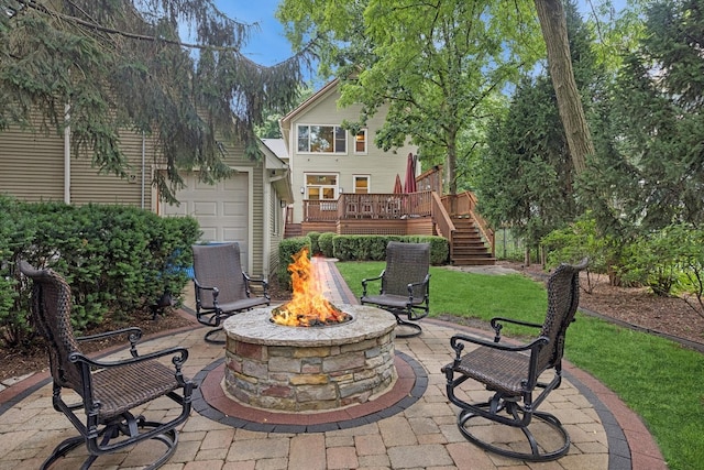 view of patio featuring stairway, an outdoor fire pit, a deck, and a garage