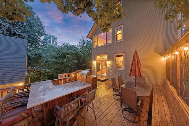 deck with outdoor dining area and a grill