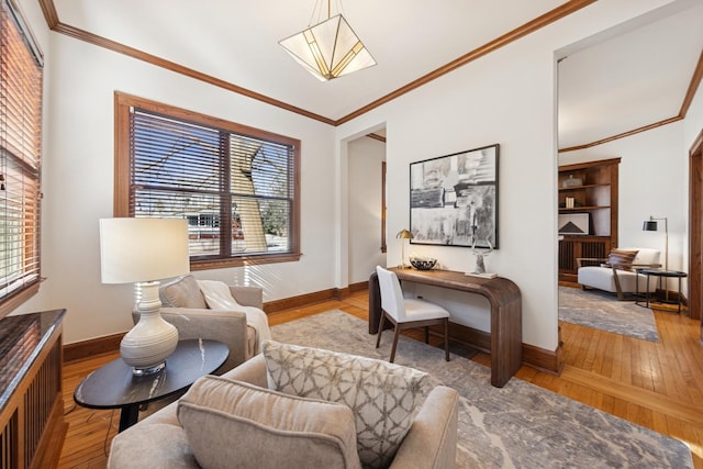 living area with crown molding, hardwood / wood-style flooring, and baseboards