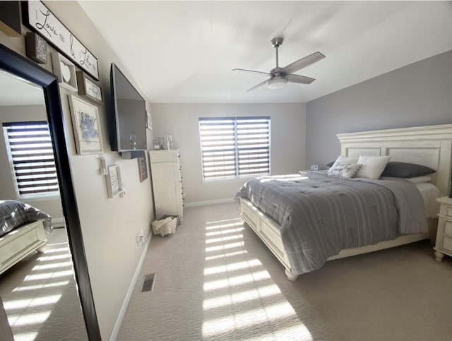 bedroom with lofted ceiling, baseboards, visible vents, and light colored carpet