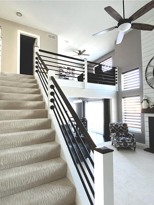 stairs featuring a wealth of natural light, visible vents, and carpet flooring