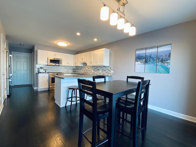 dining space with dark wood-style floors, baseboards, and recessed lighting