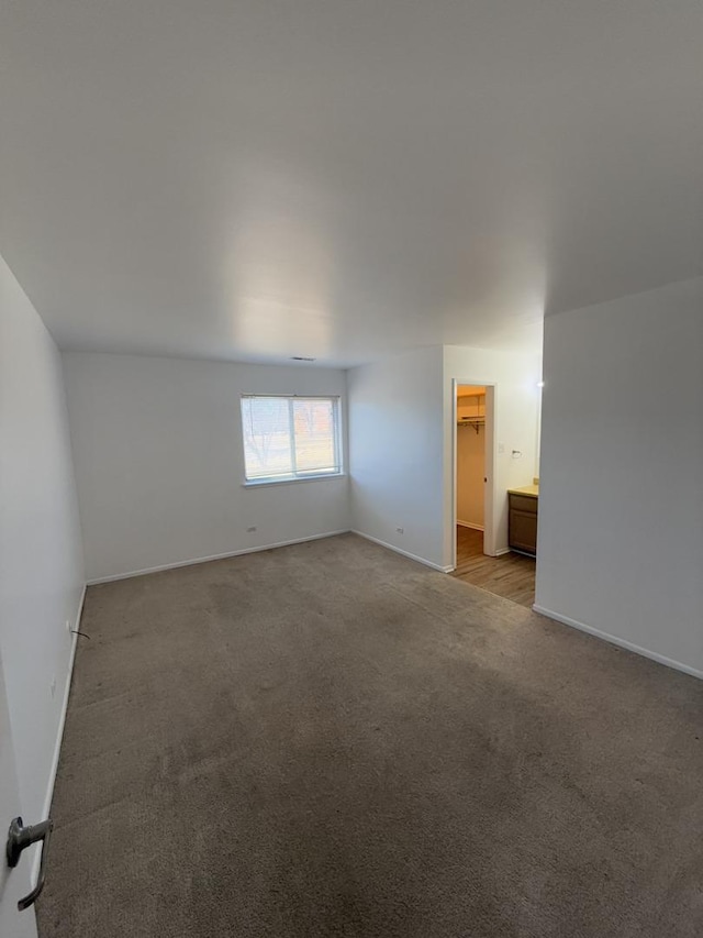 empty room featuring light colored carpet and baseboards