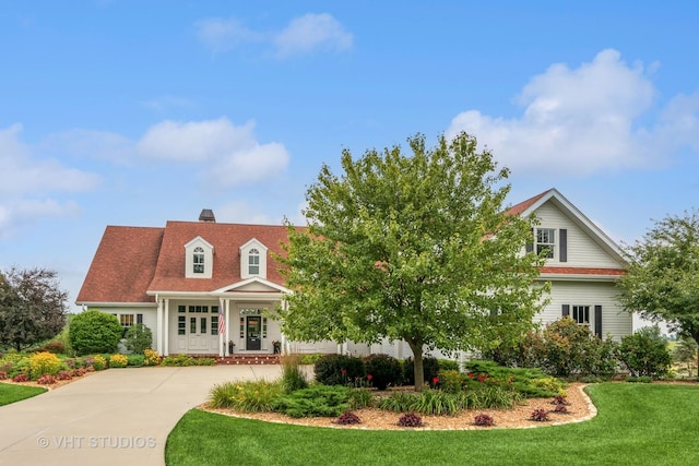 view of front of property with a front yard, driveway, and a chimney