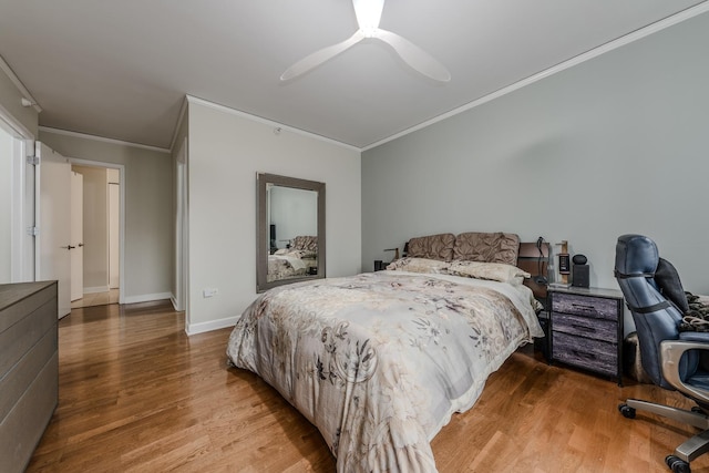 bedroom featuring ornamental molding, a ceiling fan, baseboards, and wood finished floors