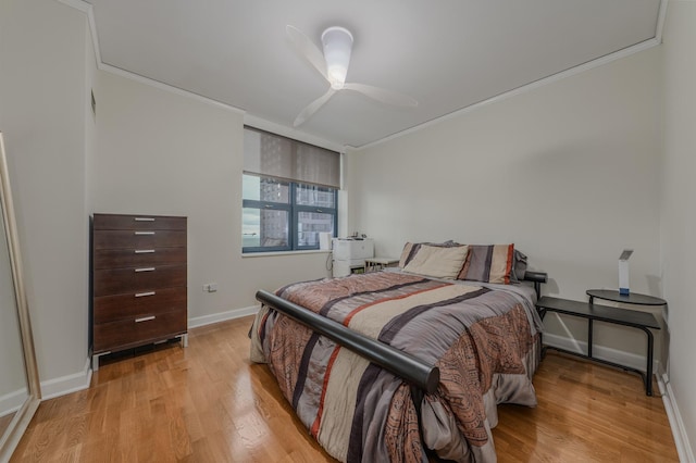 bedroom with light wood-style floors, baseboards, ornamental molding, and a ceiling fan